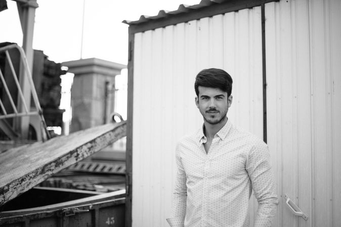 Confident man in shirt on background of industry building