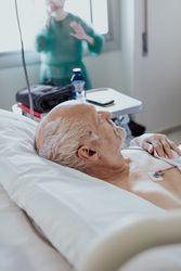 Older man admitted to a hospital room.
