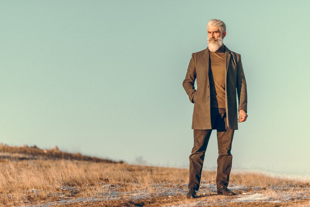 Man in brown coat standing on outdoor