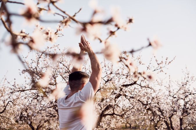 Man doing yoga in spring garden