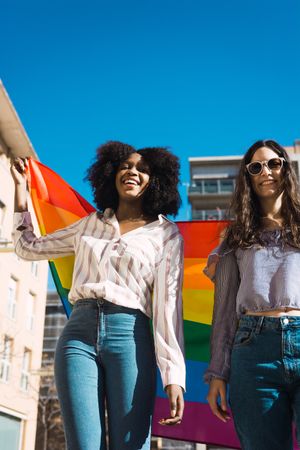 Lesbian couple walking with LGBT flag