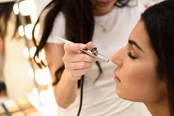 Woman having airbrush make up applied by a professional