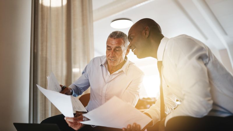 Two men preparing notes in a business setting