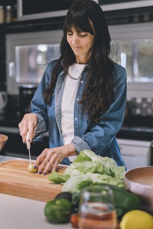 Housewife chopping baby potatoes. Vertical shot.