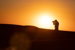 Anonymous photographer standing in desert