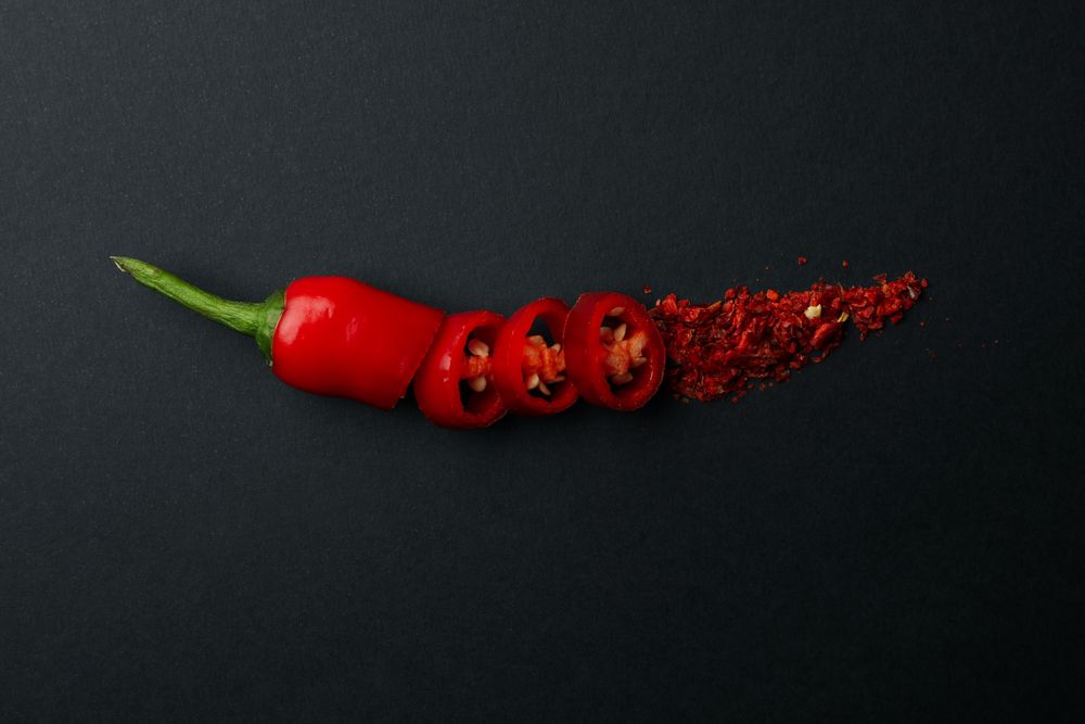 Chopped chilli pepper and spice on dark background