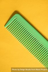 Bright green hair comb on yellow background 4ZeOd9