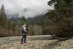 Woman in the mountains walking near a stream
