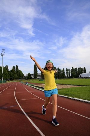 Excited young girl completing her race on running track