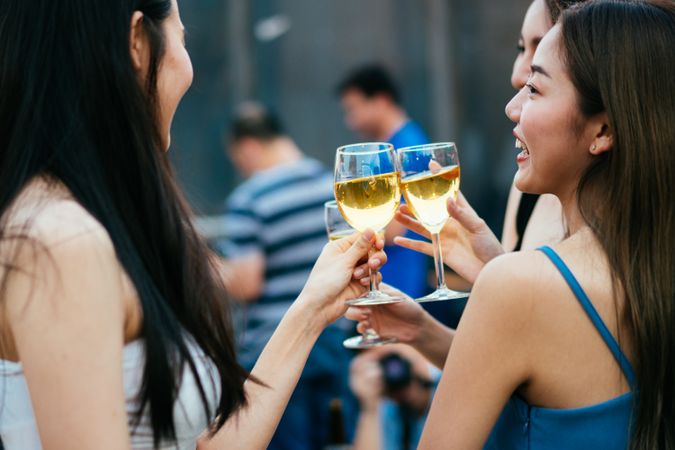 Group of happy Asian female friends with wine