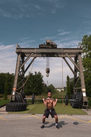 Black guy with barbell in outdoor gym