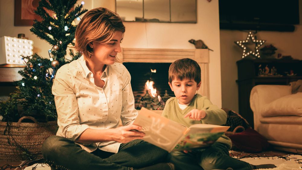 Mother reading book with son on Christmas eve