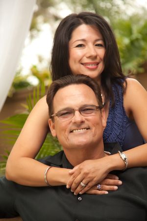 Portrait of Smiling Couple In Front Of Fern With Woman Holding Man