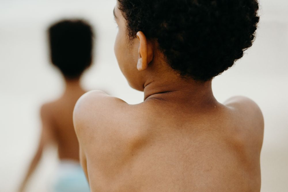Naked back of anonymous Black kid