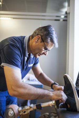 man fixing a prosthesis in a workshop