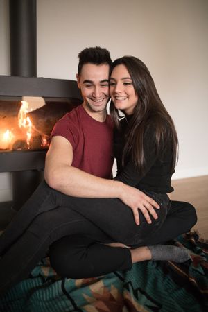 Couple sitting near fireplace on floor