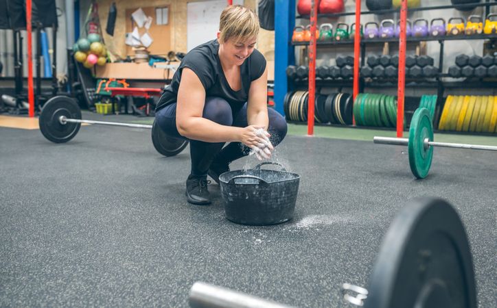 Woman applying magnesium to practice weightlifting