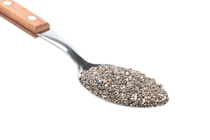 Chia seeds and spoon isolated on blank background