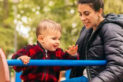 smiling mother and baby playing in a playground