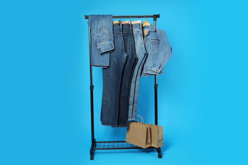 Jeans hang on hangers on a blue background