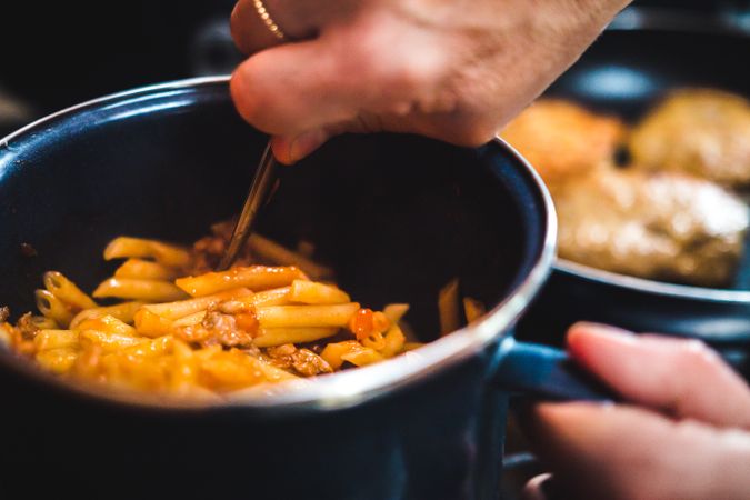 Hand cooking pasta in a saucepan