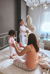 Portrait of happy mother with little boy and girl playing in bed on a relaxed morning