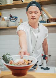 Asian man serving food bowl