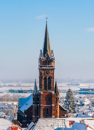 An old Alsatian town under the snow. The bell tower of the cathedral and the roofs of medieval houses.