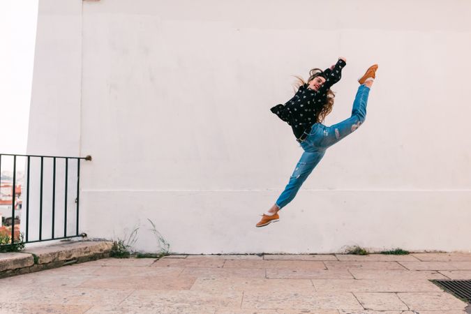 female dancer jumping against white wall