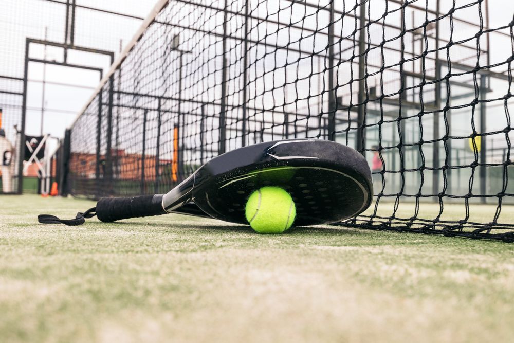 Paddle tennis racket and ball on the court