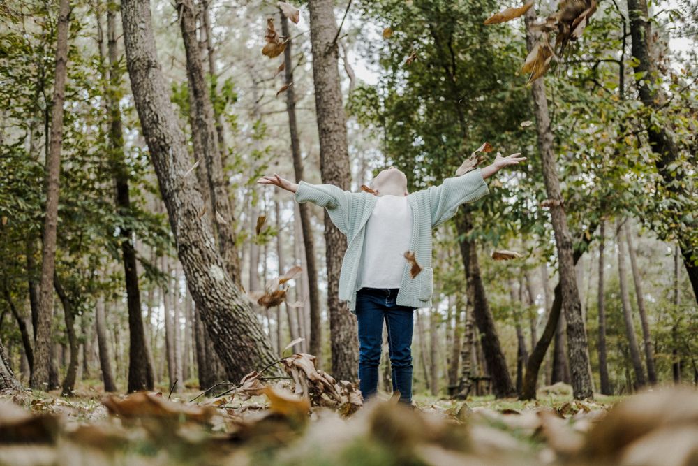 Smiling girl between meadow with dry leaves