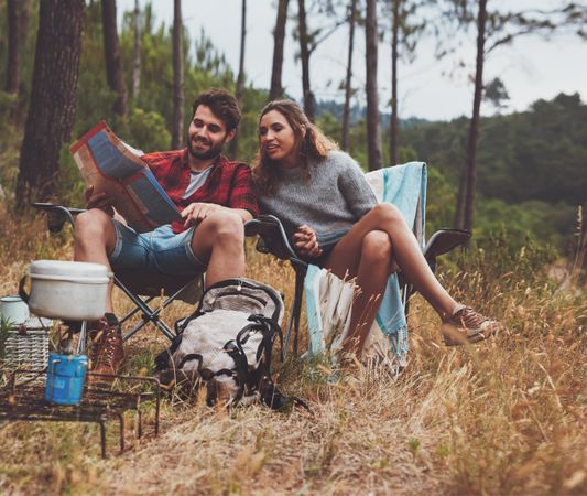 Happy young couple camping in the forest