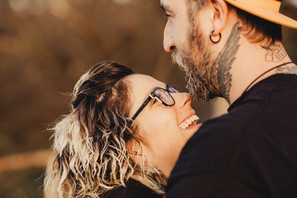 Happy couple hugging near tree in park