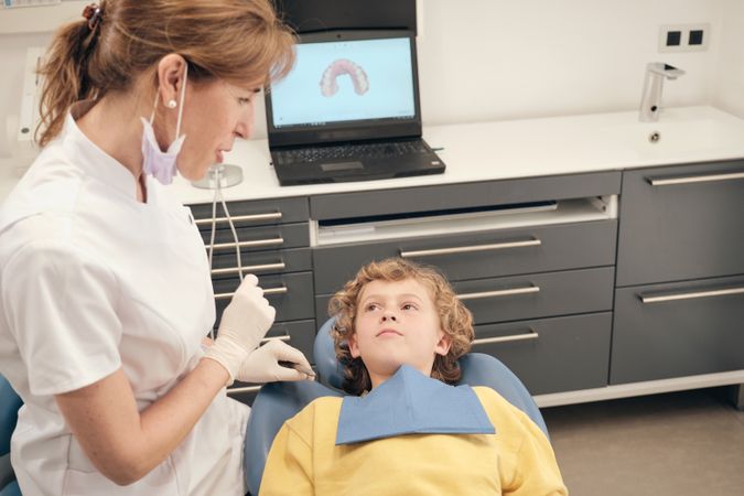 Dentist with boy in medical clinic