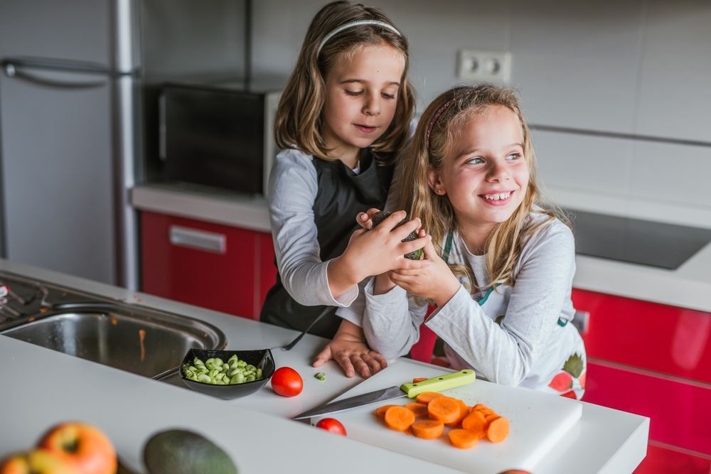Little girl showing cut avocado