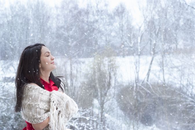 Brunette woman enjoying the snowfall