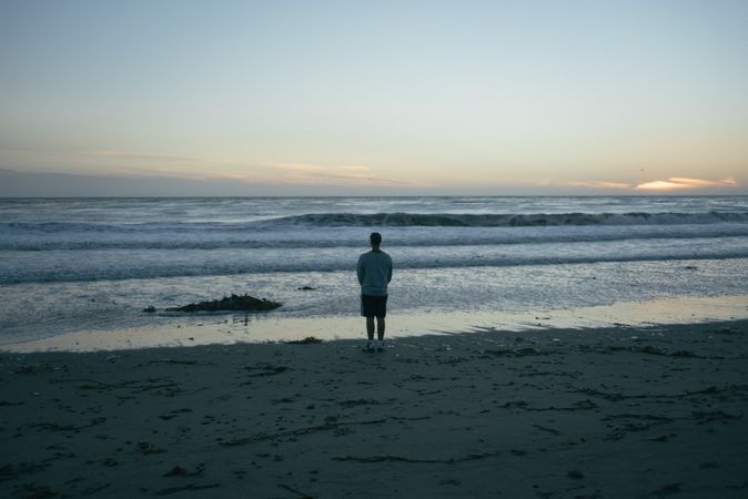 Back of man walking on beach in California