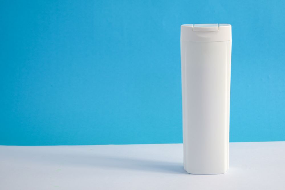 Blank shampoo bottle in blue room