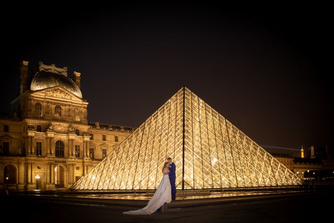 Just married couple in wedding clothing cuddling under moonlight