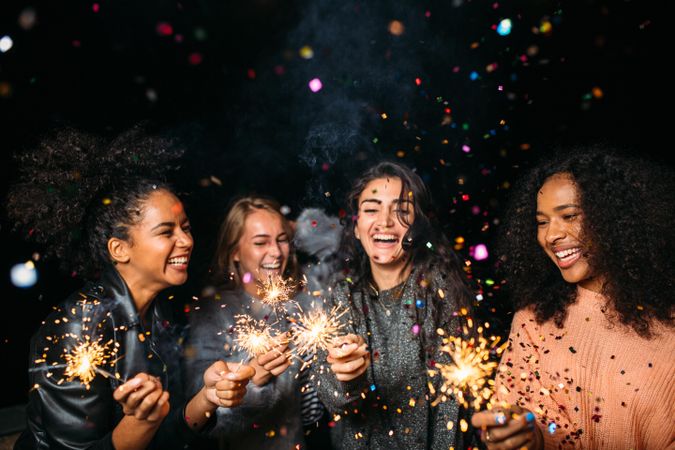 Multi-ethnic group of happy women celebrating with sparklers
