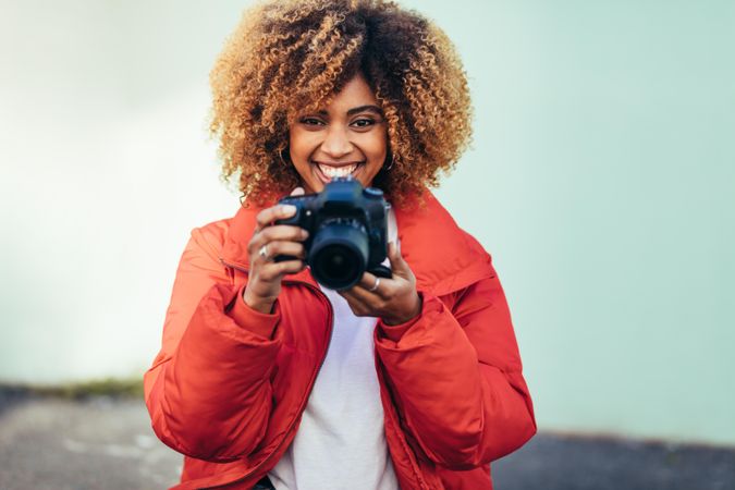 Portrait of beautiful woman holding dslr camera and smiling