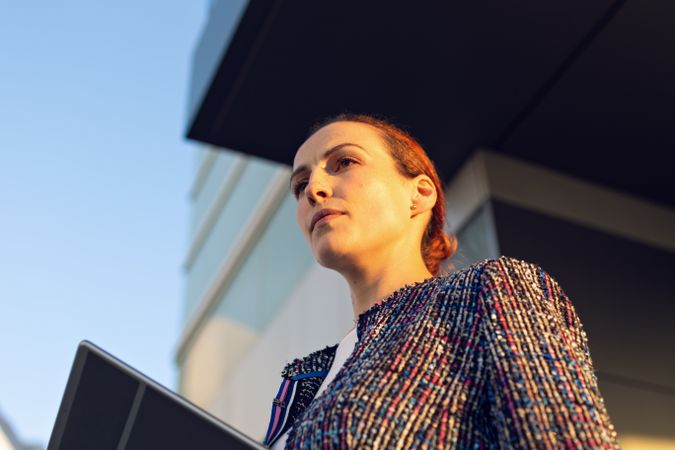 Serious businesswoman leaning on railing