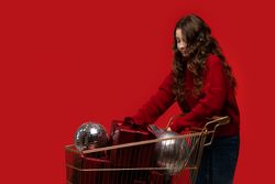Girl pushes shopping cart full of gifts and disco balls