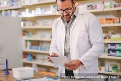 Male pharmacist reading prescription at checkout counter 5zR3k5