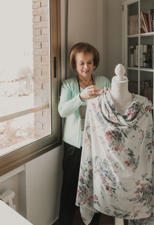Dressmaker adjusting apparel on mannequin