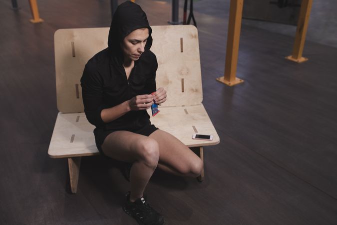 Smiling woman with energy bar in gym