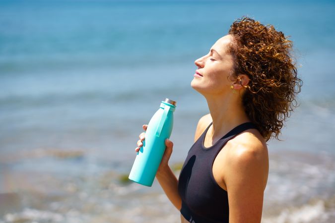 Happy sportswoman with bottle of water