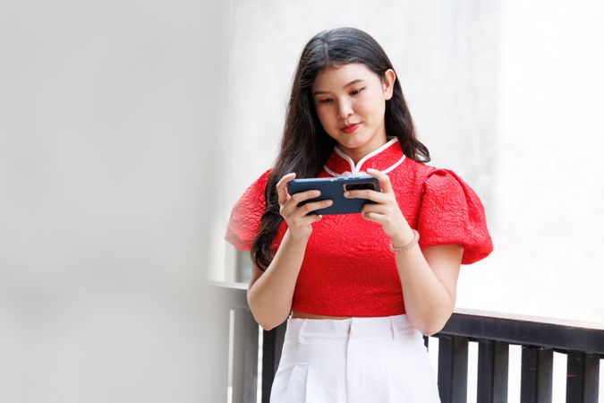 Asian woman in Chinese New Year costume chatting on mobile phone