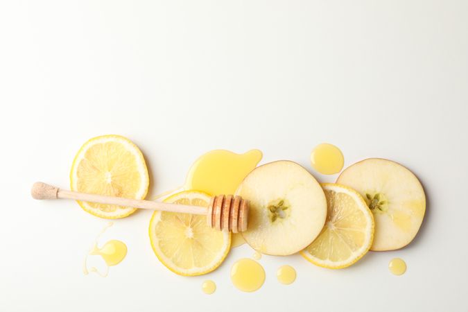 Dipper, honey, apple and lemon slices on blank background, top view