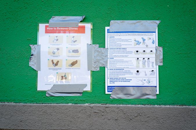 Sign taped to wall at testing site with instructions on how to remove gloves safely